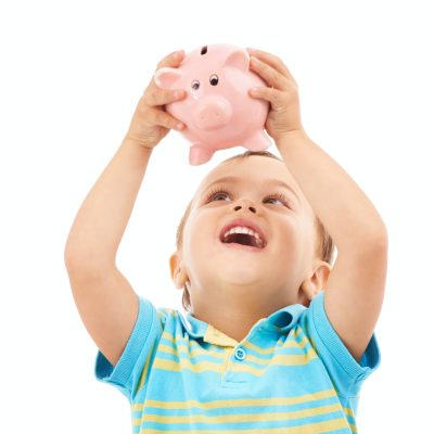 Studio shot of a young boy holding up a piggy bank isolated on white